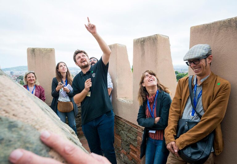 Group of visitors during a tour of Torre Bellesguard, with a guide pointing out architectural details during GWC 2016 Barcelona