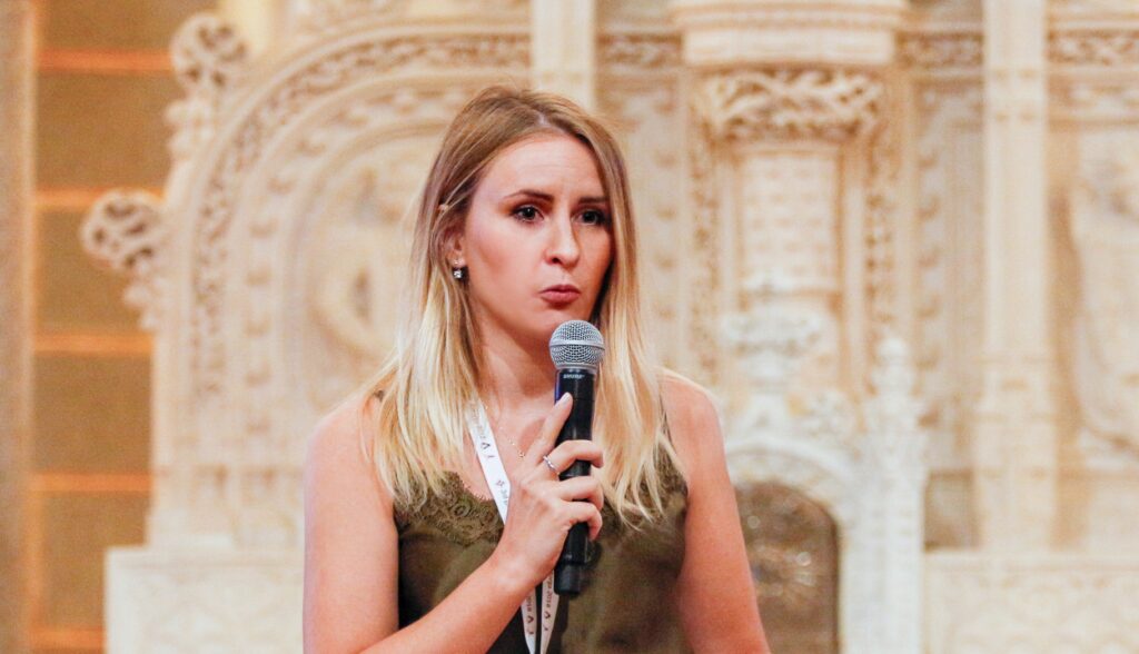 Sofya Abramchuk, Gaudí World Foundation expert, presenting during an event with an ornate architectural background.